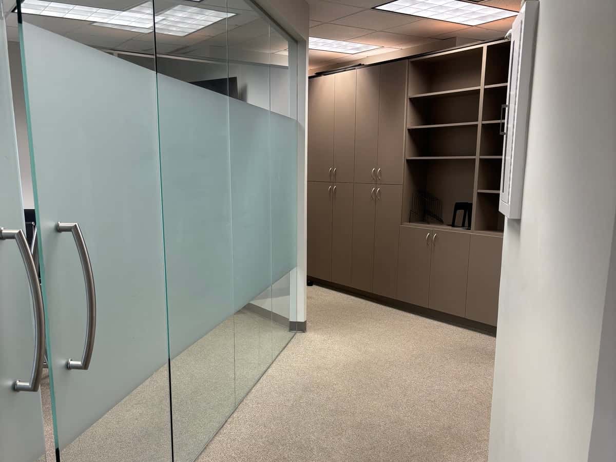 Office suite with frosted glass partitions and freshly vacuumed carpet after Guardian office cleanup