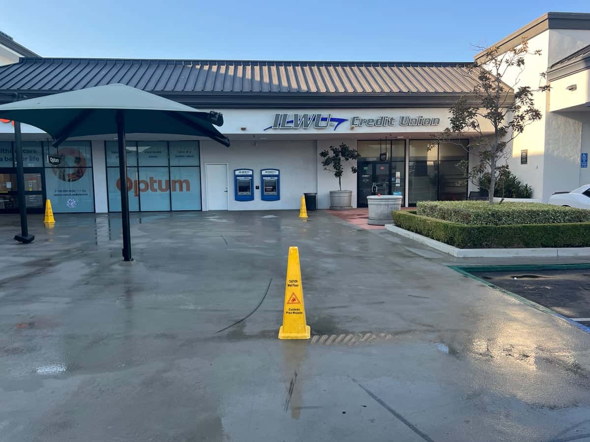 Clean concrete plaza and storefronts after a Guardian pressure wash, planters trimmed and walkway drying