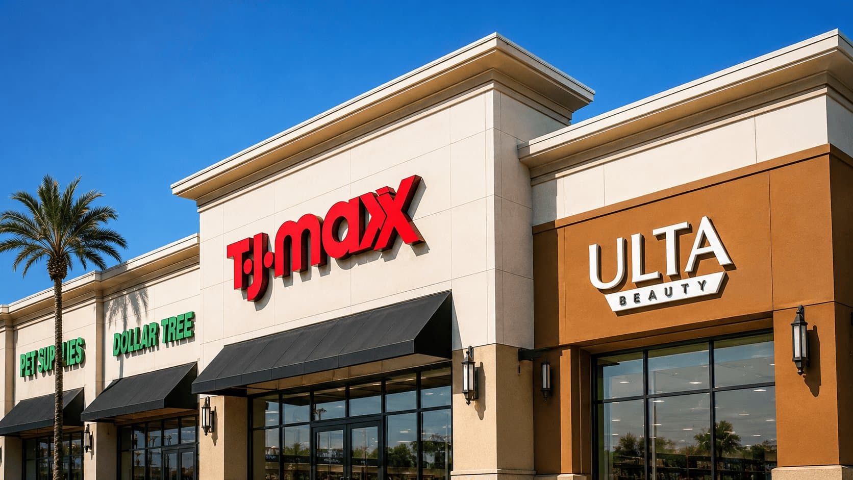 Clean storefront facades at a Southern California retail plaza under a clear blue sky