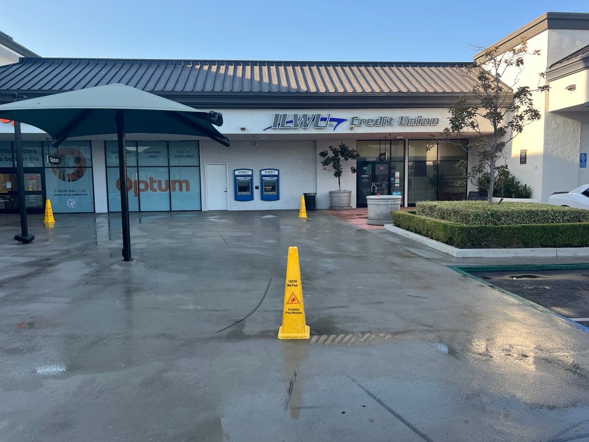 Clean concrete plaza and storefronts after a Guardian pressure wash, planters trimmed and walkway drying